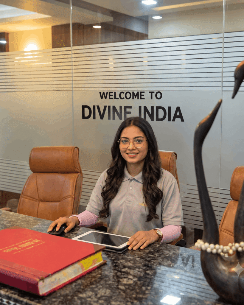A professional young Indian woman sitting at a reception desk in an office